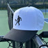 White and black cap with a tennis player silhouette on a tennis court background